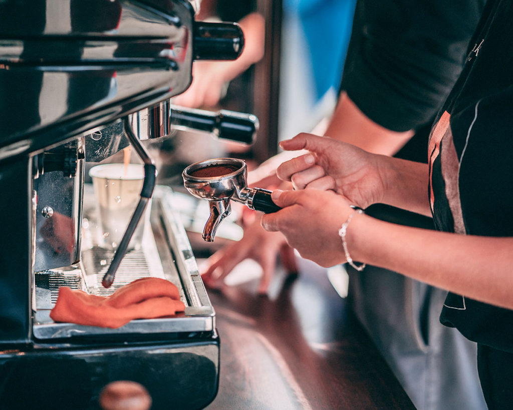 Barista na evencie przygotowuje kawę w ekspresie