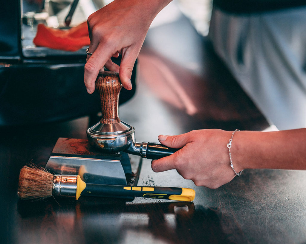 Barista na targach przygotowuje kawę w ekspresie ciśnieniowym